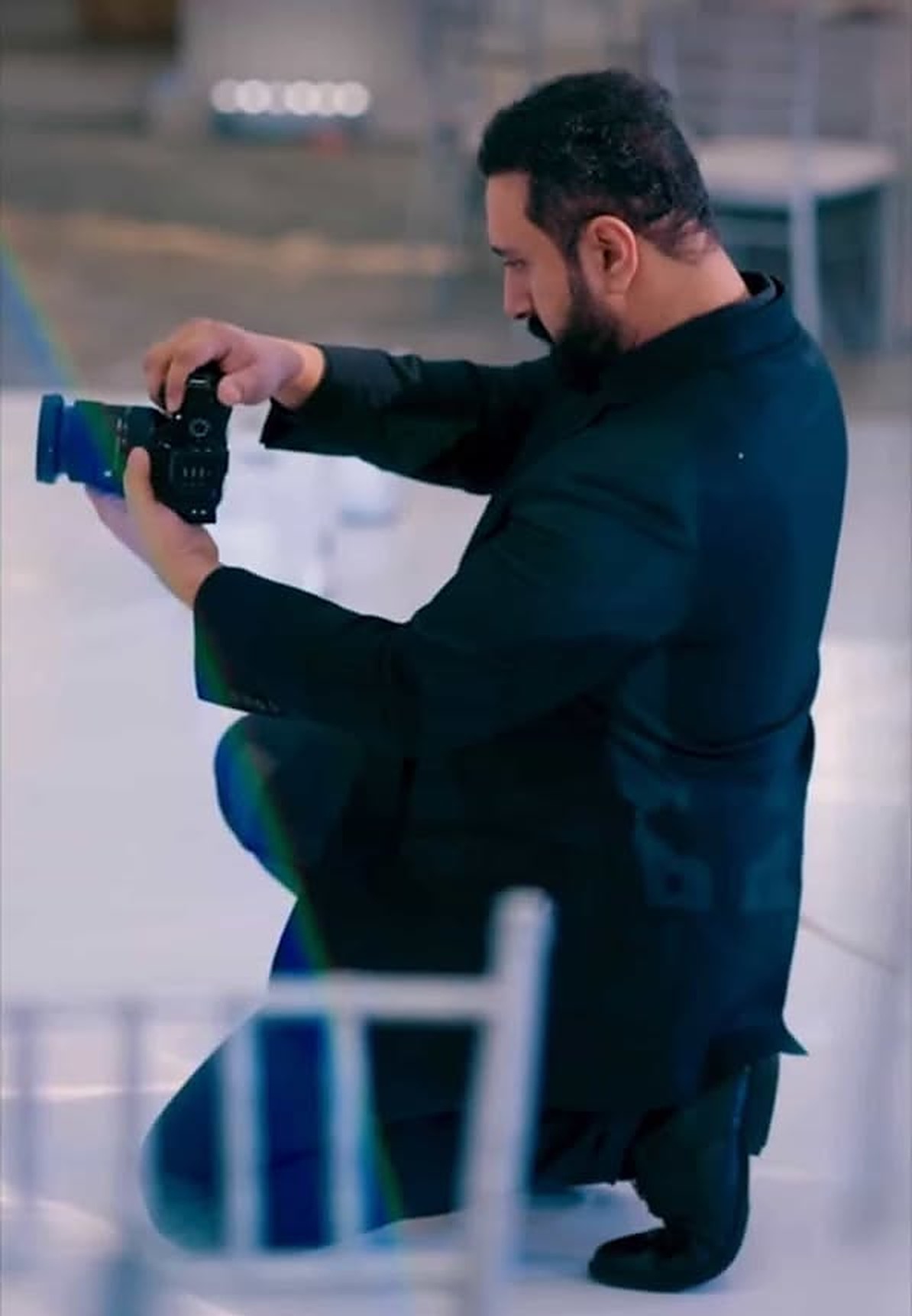 A Morni Studio photographer kneeling with his camera inside a reception venue